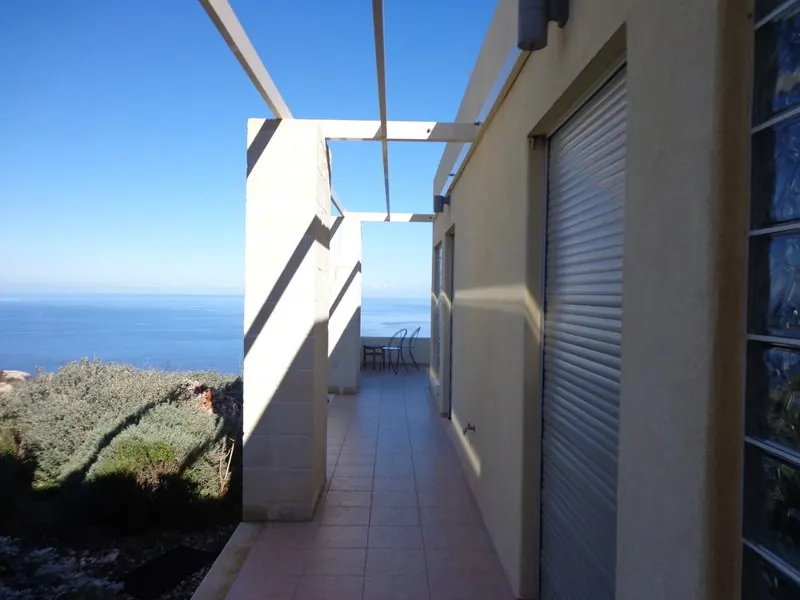 Covered walkway between the guest rooms and the house, looking out to sea