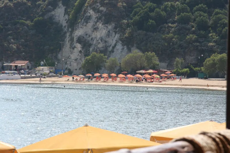A wide turquoise bay curving towards green hills