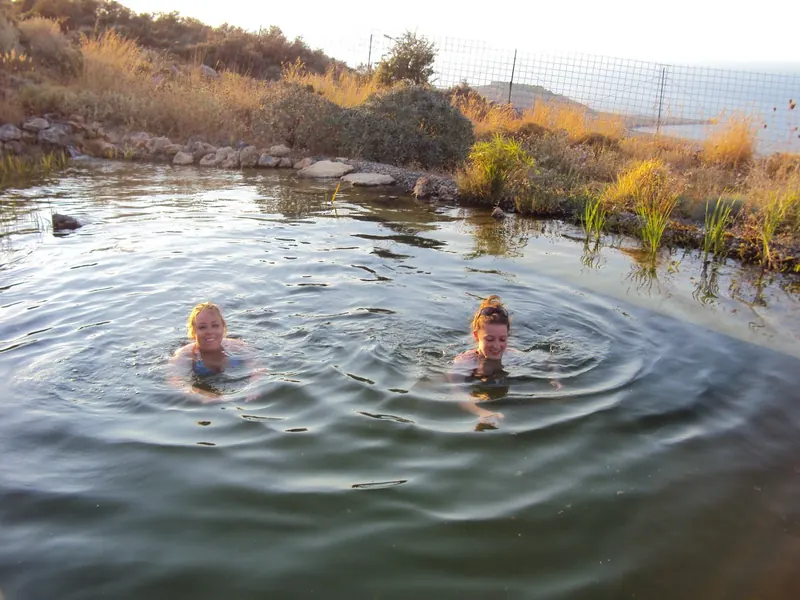 Two guests swimming in the natural pool